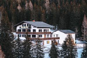 a large white house in the snow with trees at Edelweiss Lodge Lachtal I Self Check-in in Lachtal