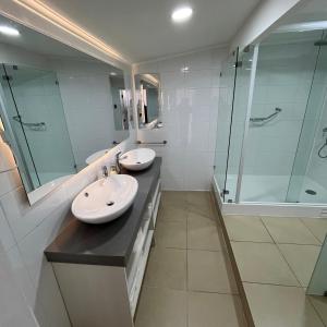 a bathroom with two sinks and a shower at Hotel Carande, Papudo in Papudo +17 photos