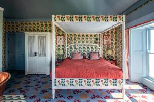 a bedroom with a canopy bed with a red bedspread at Armada House in Spanish Point