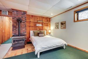 una camera con letto e stufa a legna di Porch and Views Queensbury Three Family Lakehouse a Queensbury