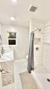 une salle de bain blanche avec une douche et un lavabo dans l'établissement LRG 1600sqft 4room 2 bath in a quiet neighborhood, à Bakersfield 40 autres photos