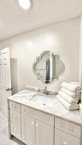 une salle de bain blanche avec un lavabo et un miroir dans l'établissement LRG 1600sqft 4room 2 bath in a quiet neighborhood, à Bakersfield