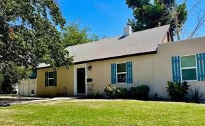 une maison blanche avec des volets bleus et une cour dans l'établissement LRG 1600sqft 4room 2 bath in a quiet neighborhood, à Bakersfield