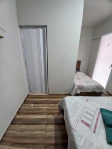 Habitación pequeña con 2 camas y puerta en SUÍTE NOMAR 1 campos prado, en Brotas 5 fotos más