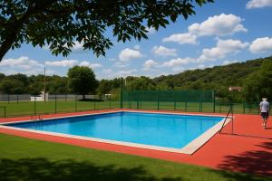 a person walking by a swimming pool on a field at La Casita de Rosi in Navaluenga
