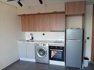 a kitchen with a washing machine and a refrigerator at Casablanca Luxury Studio - Family & Solo Friendly in Casablanca +4 photos