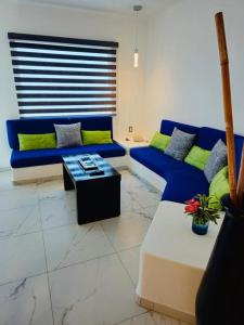 a living room with a blue couch and a table at departamento frete al mar in Manzanillo
