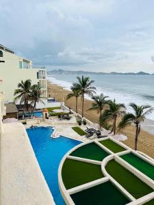 a view of a resort with palm trees and the ocean at departamento frete al mar in Manzanillo