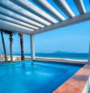 a swimming pool with a view of the beach at departamento frete al mar in Manzanillo