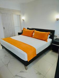 a bedroom with a large bed with orange pillows at departamento frete al mar in Manzanillo