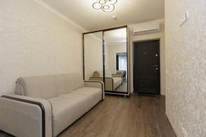 een woonkamer met een bank en een spiegel bij Apartament Centru Chisinau in Chişinău