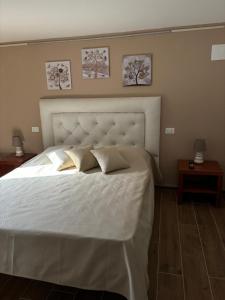 Un dormitorio con una gran cama blanca con dos almohadas. en b&b JCM, en Ponte della Venturina