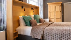 a bedroom with a large bed with green pillows at Villa Valkenburg in Valkenburg +10 photos