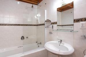 a white bathroom with a sink and a bath tub at Stonebreaker Country Lodge in Oudtshoorn +35 photos