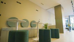 una habitación con tres mesas y sillas verdes en Hostal Superlativo Trinidad, en Málaga