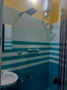 a bathroom with a sink and a mirror at Krishnamandiram in Paravūr +7 photos