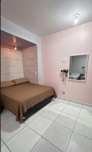 カボ・フリオにあるCasinha de Temporadaのベッドと壁にテレビが掛かった寝室