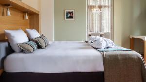 a bedroom with a large white bed with pillows at Villa Valkenburg in Valkenburg