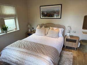 ホルムファースにある"The Lodge", Holmfirthの白いシーツと枕が付いた大きなベッドのある寝室