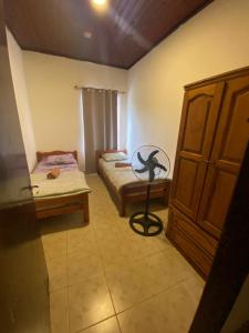 a small room with two beds and a cabinet at Mango Home - Casa privada con pileta in Puerto Iguazú +20 photos