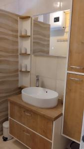 a bathroom with a white sink and a mirror at More in Vodice
