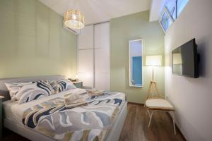a bedroom with a bed and a tv on a wall at Atelier LAKOTA in Brtonigla