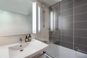 a bathroom with a sink and a shower and a mirror at FirstName Toulouse Résidence in Toulouse +32 photos