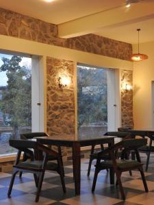 a table and chairs in a room with a stone wall at Jawai-e-khaas in Bijāpur