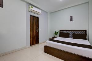 Un dormitorio con una cama y una ventana grande. en Hotel O Dadri Main Road Greater Noida, en Greater Noida