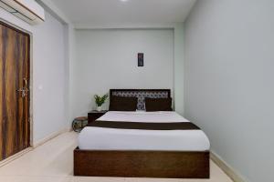 a bedroom with a bed in a white room at Hotel O Dadri Main Road Greater Noida in Greater Noida +13 photos