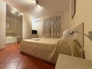 a room with a bed with a lamp and a bathroom at Home Sweet Home Affittacamere - Lucca in Lucca