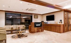 a hotel lobby with a reception desk and a flat screen tv at Townhouse Oak Salt Lake Kolkata Formerly SLS Tower in Thākurdwari +7 photos