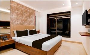 a bedroom with a large bed and a window at Townhouse Oak Salt Lake Kolkata Formerly SLS Tower in Thākurdwari