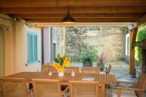 a wooden table with yellow flowers on a patio at Atelier LAKOTA in Brtonigla