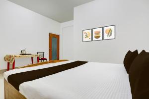 GulzārbāghにあるHotel O Stay Inn & Restaurantの白いベッドルーム(ベッド1台、テーブル付)