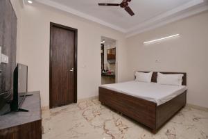 a bedroom with a bed and a flat screen tv at Collection O DLF Cyberhub Gurugram in Gurgaon