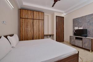 a bedroom with a large bed and a tv at Collection O DLF Cyberhub Gurugram in Gurgaon