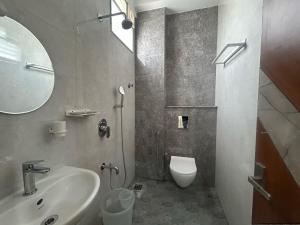 a bathroom with a sink and a toilet and a mirror at Hotel O Jodi Sri Muneshwara Swamy Temple in Jālahalli +7 photos