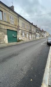 an empty street with a green door on a building at Rustique Chic proche centre-ville in Clermont