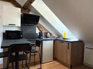 a kitchen with a counter with a sink and a microwave at Rustique Chic proche centre-ville in Clermont