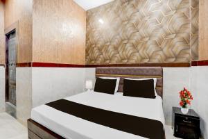 a bedroom with a bed and a wall at Hotel O Brij Ghat Mukteshwar Formerly Brijwasi Guest House in Kankather