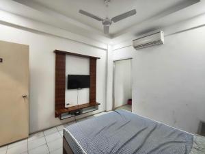 a bedroom with a bed and a flat screen tv at Collection O Warje Pune Formerly Choice Guest house in Yerandwane