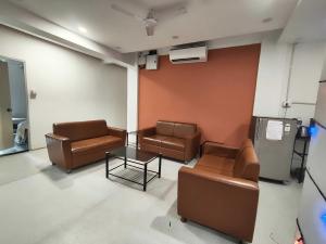 a waiting room with leather chairs and a table at Collection O Warje Pune Formerly Choice Guest house in Yerandwane +10 photos