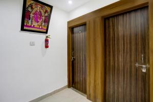 una habitación con una puerta y una foto en la pared en Hotel O Sai Teerth Theme Park Formerly Sai Dhanlaxmi, en Shirdi