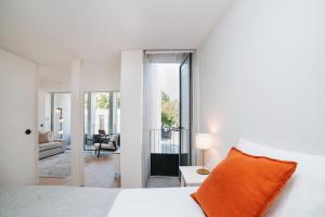 a bedroom with a white bed with an orange pillow at Apartment Oro in Braga