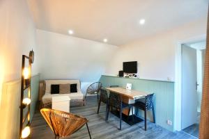 a room with a desk and a bed and a table at Tiny Loch - 150 m de la mer - piscine chauffée in Guidel