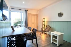 a dining room with a table and chairs at Tiny Loch - 150 m de la mer - piscine chauffée in Guidel