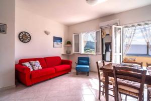 a living room with a red couch and a table at Sole di Sarda in Badesi