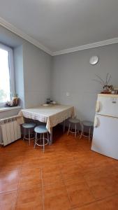 a kitchen with a table and chairs and a refrigerator at Квартира навпроти басейну in Berehove