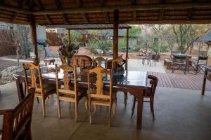 een houten eettafel en stoelen op een patio bij NIANI tented Chalet in Hoedspruit